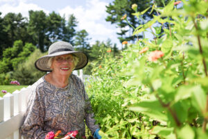Resident Barbara R. in hat gardening